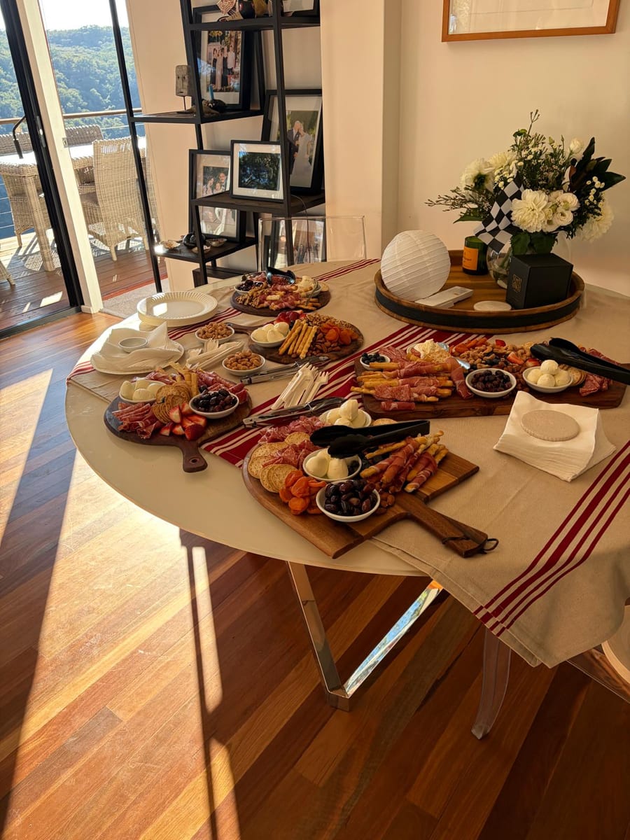 Grazing boards of prosciutto, bocconcini, olives and crackers laid out on a round table